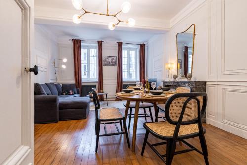 a dining room and living room with a table and chairs at L' ALCOVE- Confort Charme Downtown in Dijon