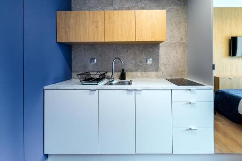 a kitchen with white cabinets and a sink at Szewska 7 Apartments in Krakow