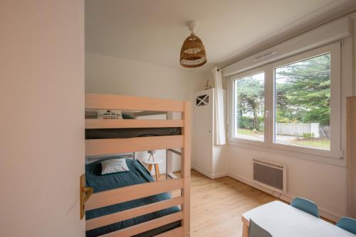 Cette petite chambre comprend des lits superposés et une fenêtre. dans l'établissement Les Roches Plates, à Fréhel