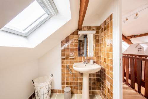 une salle de bain avec un lavabo et un miroir dans l'établissement Les Roches Plates, à Fréhel