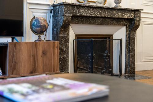 a fireplace with a globe on top of it at L' ALCOVE- Confort Charme Downtown in Dijon