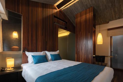 ein Schlafzimmer mit einem großen Bett mit blauen Kissen in der Unterkunft Concon house in Hanoi