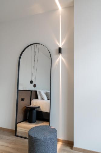 a bedroom with a mirror and a blue stool at Athens Woo Suites in Athens
