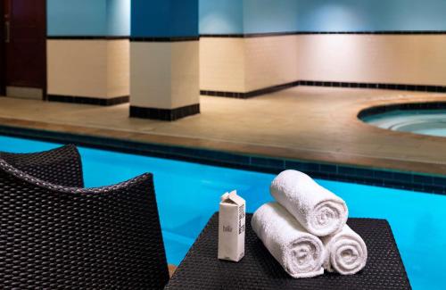 a pile of towels on a table next to a pool at The Stephen F Austin Royal Sonesta Hotel in Austin