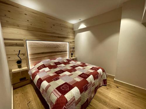 une chambre avec un lit et un mur en bois dans l'établissement PETITE OURSE - Centre village et proche pistes, à La Clusaz