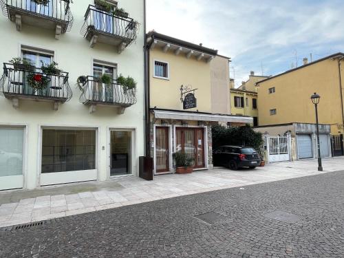 a building with balconies and a car on a street at Lucia Holiday Apartments in Lazise