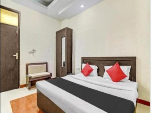 a bedroom with a large bed with red pillows at Om Sai Nath Hotel & Restaurant By WB Inn in Agra
