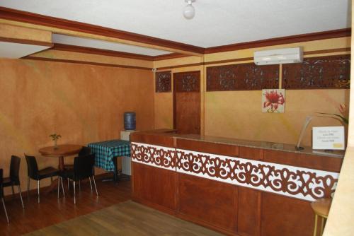 a restaurant with a counter and a table and chairs at RedDoorz Plus at Balai Sofia Bed & Breakfast Batangas in Talisay