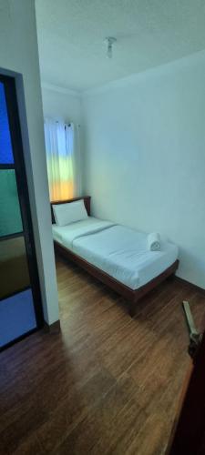 Łóżko w pokoju z drewnianą podłogą w obiekcie RedDoorz Plus at Balai Sofia Bed & Breakfast Batangas w mieście Talisay