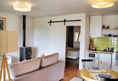 a living room and kitchen with a couch and a stove at Casas de Alpedrinha in Alpedrinha