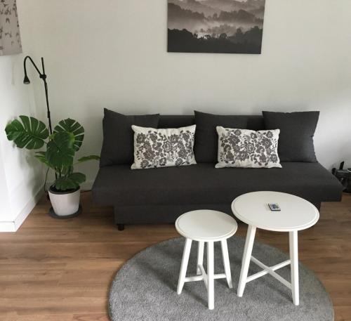 a living room with a couch and two tables at DeichApartments70-78 in Bremerhaven