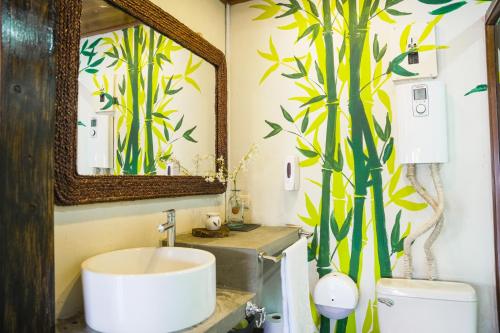 a bathroom with a sink and a mirror and a toilet at Boutike Art & Wellness in Concepción de Ataco