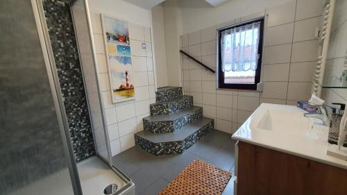 a bathroom with a shower and a staircase with a sink at Gästezimmer & Ferienwohnungen Thon in Herbsleben