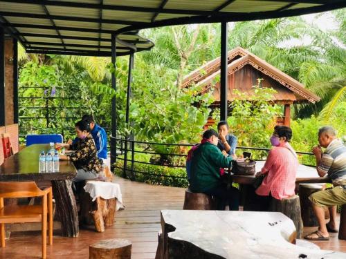 un groupe de personnes assises à des tables sur une terrasse dans l'établissement กอบสุข รีสอร์ท2 k02, à Ban Ton Liang