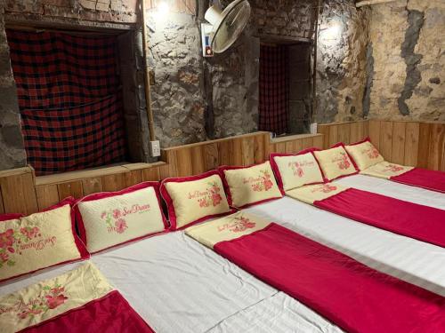 Duas camas com almofadas vermelhas e brancas num quarto em Trường Giang Homestay em Cao Bang