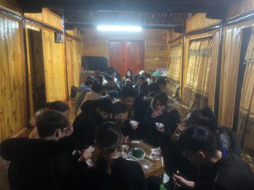 um grupo de pessoas sentadas à volta de uma mesa a comer em Trường Giang Homestay em Cao Bang