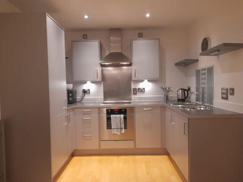 a kitchen with white cabinets and a stove top oven at Centrally situated 1 bedroom apartment! in Birmingham