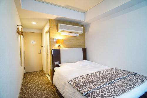 a small bedroom with a bed in a room at Hotel BRS Hakodate Goryokaku Tower Mae in Hakodate