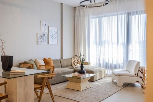 a living room with a couch and a table at 2BR Le Pont B3 Full Sea and Pool View in Dubai