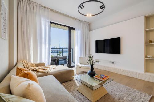 a living room with a couch and a tv at 2BR Le Pont B3 Full Sea and Pool View in Dubai