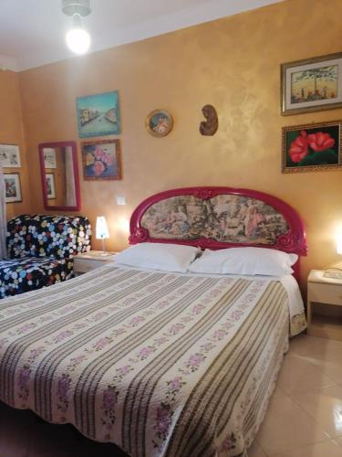 um quarto com uma cama grande e uma cabeceira vermelha em Porta di Roma locazione turistica em Roma
