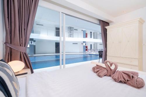 a bedroom with a bed and a large window at sunset plaza condominium by Ryan, 600 meters to Karon Beach in Karon Beach
