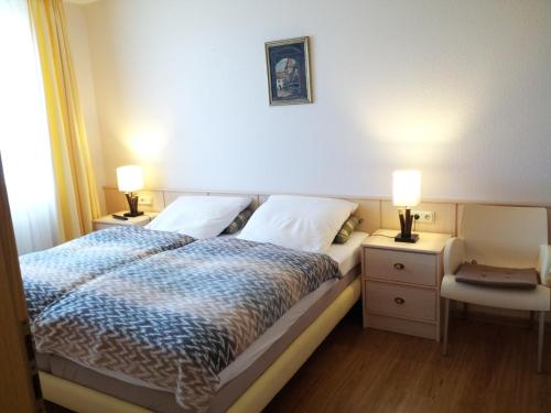 ein Schlafzimmer mit einem Bett mit zwei Nachttischen und zwei Lampen in der Unterkunft Kurpark-Residenz 206 in Döse