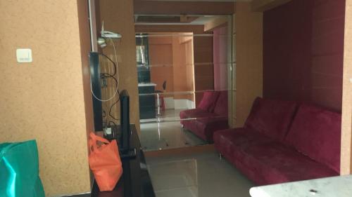 a living room with two red couches and a mirror at Lily's Room in Cibubur