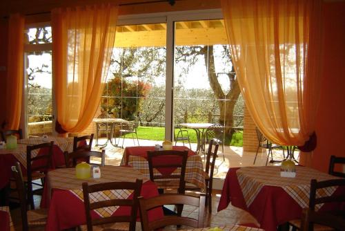 a restaurant with tables and chairs and a large window at Agriturismo Le Tese in Colà di Lazise