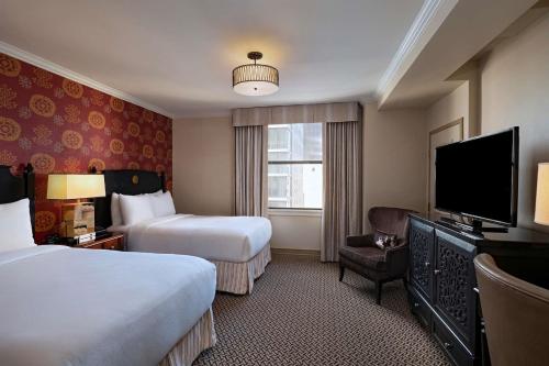 um quarto de hotel com duas camas e uma televisão de ecrã plano em The Stephen F Austin Royal Sonesta Hotel em Austin