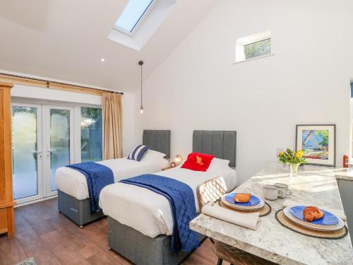 a bedroom with two beds and a table with plates on it at Little Osney in Bembridge