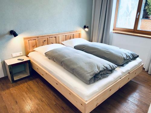 a bed with two pillows on it in a bedroom at Das Stubai - exklusiv, einzigartig & nachhaltig in Fulpmes