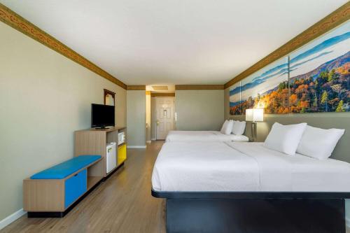a hotel room with two beds and a tv at Days Inn by Wyndham Mountain Home in Mountain Home