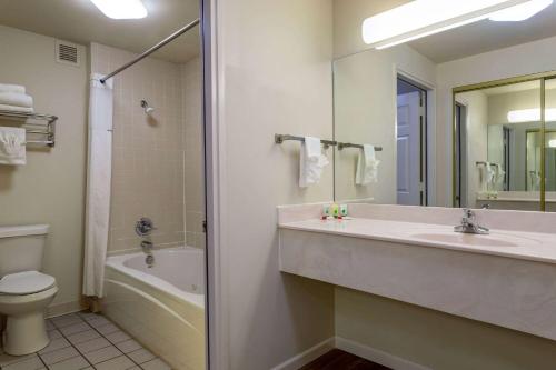 a bathroom with a sink and a tub and a toilet at Days Inn by Wyndham Mountain Home in Mountain Home