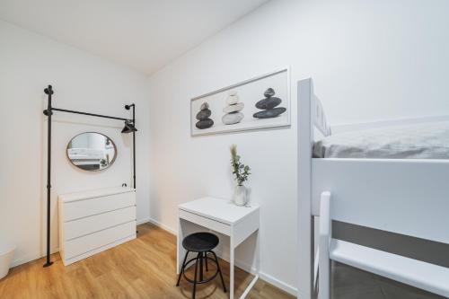 a bedroom with a bed and a desk with a mirror at Central City Rooms by Home2 in Vienna