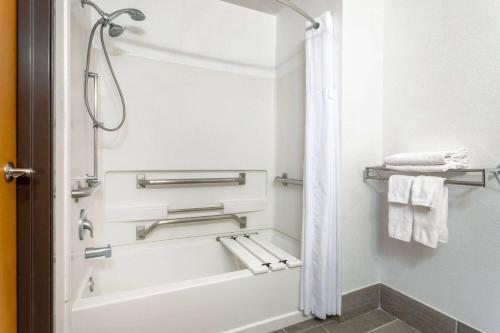 a bathroom with a tub and a shower with towels at Super 8 by Wyndham The Dalles OR in The Dalles