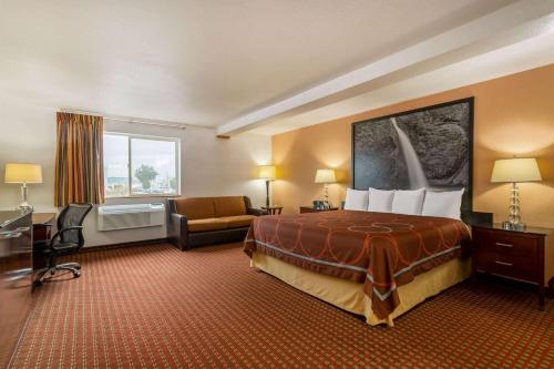 a hotel room with a large bed and a couch at Super 8 by Wyndham The Dalles OR in The Dalles