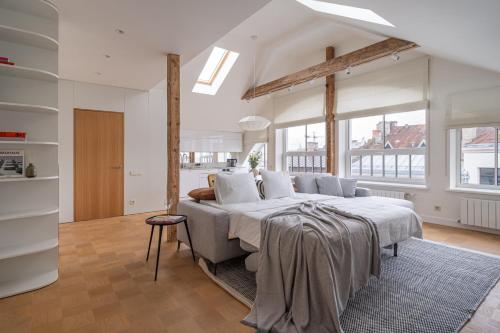 1 dormitorio con 1 cama grande en una habitación con ventanas en Bright Designer Apartment In City Centre, en Riga