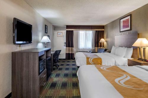 a hotel room with two beds and a flat screen tv at Quality Inn On Historic Route 66 in Barstow