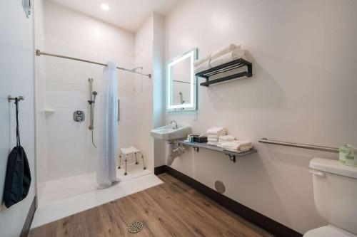 a bathroom with a shower and a sink and a toilet at MainStay Suites Colorado Springs East - Medical Center Area in Colorado Springs