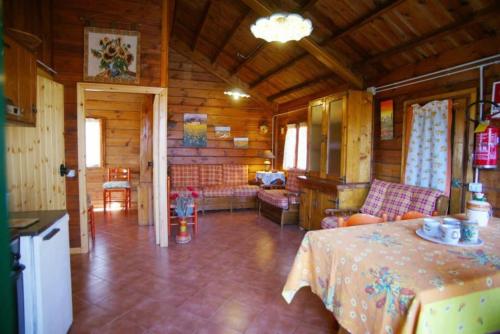 ein Wohnzimmer mit einem Tisch in einer Hütte in der Unterkunft CHALET ETNA MILO in Milo