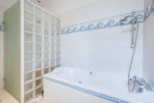 une salle de bain blanche avec une baignoire et un lavabo dans l'établissement Grand appartement 8 personnes terrasse privative hyper centre calme, à Lons-le-Saunier