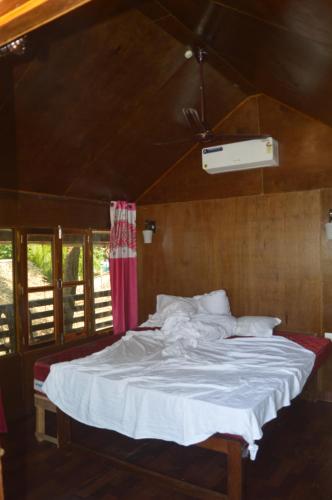 a bedroom with a bed with a white bedsheet at Soulmate Beach Resort in Agonda
