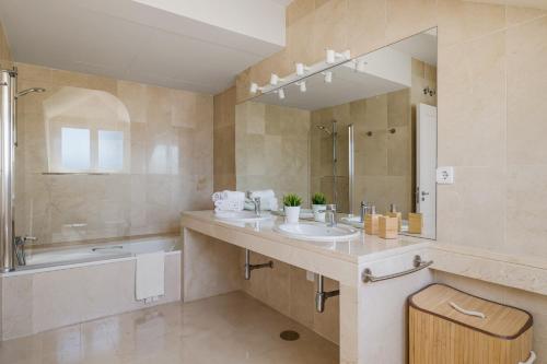 uma casa de banho com um lavatório, uma banheira e um espelho. em Luxury Penhouse, Sotogrande Marina - Located in an exclusive island of the Marina em Sotogrande