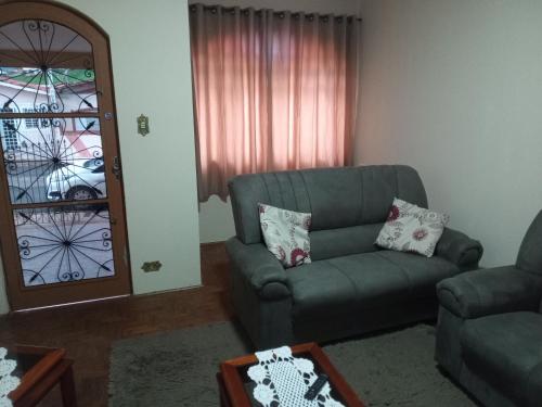 a living room with a couch and a chair at Casinha in Socorro