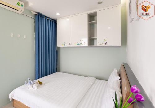 um quarto com uma cama e uma cortina azul em Sunrise City - 1 Bed Room - Full Furniture - City View em Ho Chi Minh