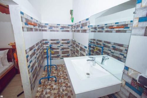 a bathroom with a sink and a bath tub at Hotel National Ambilobe in Ambilobe