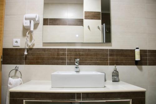 a bathroom with a white sink and a mirror at São Pedro Country House in Campo Maior