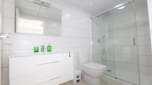 ein weißes Bad mit einem WC und einer Dusche in der Unterkunft REF 9959 Green Apartment La Marina in Elche