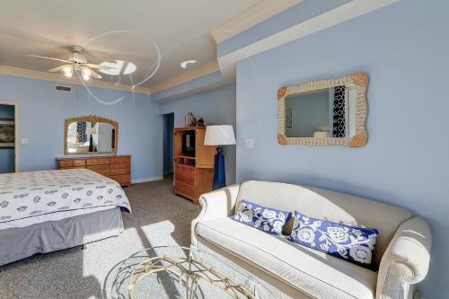 - une chambre avec un lit, un canapé et un miroir dans l'établissement Seacrest - Unit PH3, à Île de Hilton-Head